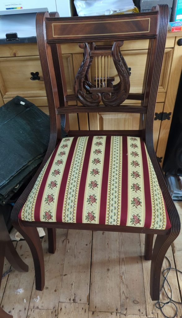 Restored Regency mahogany dining chair with carved lyre back and floral striped seat cushion